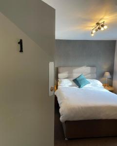 CalveleyTollemache Arms的卧室配有白色床和蓝色枕头