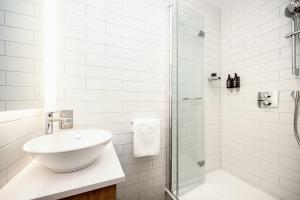 曼彻斯特Wilde Aparthotels Manchester St. Peters Square的白色的浴室设有水槽和淋浴。