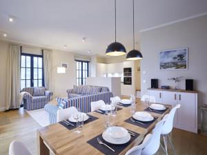德兰斯克Reetland am Meer - Luxus Reetdachvilla mit 3 Schlafzimmern, Sauna und Kamin F15的用餐室以及带桌椅的起居室。