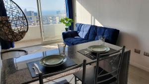 安托法加斯塔Antofagasta Sunset - Amplio Departamento con Home Office y Vista Mar的客厅配有桌子和蓝色沙发