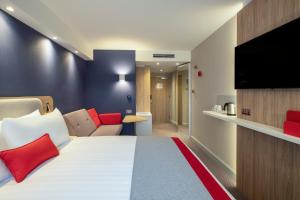 剑桥Holiday Inn Express Cambridge West - Cambourne, an IHG Hotel的配有一张床和一台平面电视的酒店客房
