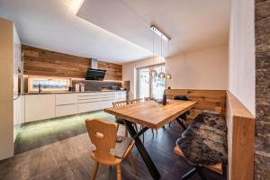 迈尔霍芬Chalet Alpendomizil Ahorn的厨房以及带木桌和椅子的用餐室。