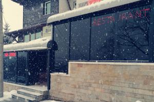 VladayaDiscret Hotel & Restaurant的一座建筑物前的雪地里的一个火车站