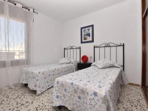 托里代巴拉Apartment Magnolia by Interhome的一间卧室设有两张床和窗户。