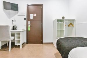 巴塞罗那Laramond Barcelona Rooms的卧室配有床、书桌和门