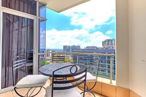 约翰内斯堡Comfort Apartment SA的市景阳台配有桌椅。