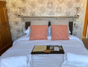 Nawton普兰普顿苑大酒店的一张带两个枕头的床和一本书