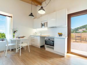 班亚布法Holiday Home Sa Caseta des Camp by Interhome的厨房配有白色橱柜、桌子和用餐室。