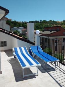 RoccascalegnaPrimae Noctis Apartments的阳台配有2把蓝色和白色椅子