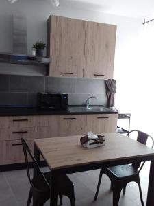 RoccascalegnaPrimae Noctis Apartments的厨房配有木桌、椅子和水槽