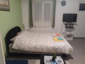 蒂瓦特Apartmani Irena的一间小卧室,配有一张床和电视