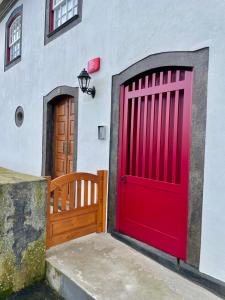 普拉亚达维多利亚Casa do Avô José Alves的白色建筑上两个红色车库门