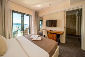 布德瓦亚历山大拉法鲁维奇酒店的配有一张床、一张书桌和一扇窗户的酒店客房
