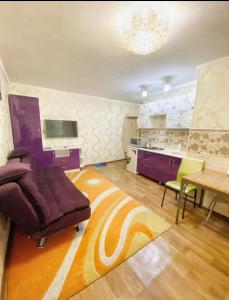 阿拉木图Apartments Ahmetova 4 21的带沙发和桌子的客厅以及厨房。