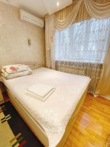 阿拉木图Apartments Ahmetova 6 32的一间小卧室,配有一张带窗户的床