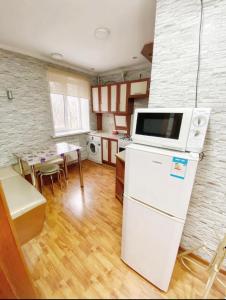 阿拉木图Apartments Ahmetova 6 32的厨房配有白色冰箱和桌子