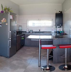 马拉圭Mi casa es tu casa!!的厨房配有冰箱和2个吧台凳