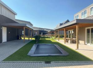 坎珀兰luxe Villa Maroma Regal aan Veerse meer met 4 Ebikes GasBBQ & EV laadpaal的房屋中间带游泳池的院子