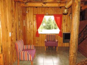 维拉梅利奎纳Las Cuatro Lunas的客厅配有两把椅子和窗户