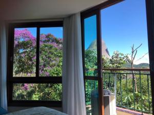 佩德拉阿祖尔Flat Vista Azul Hotel的客房设有窗户,享有树林美景。