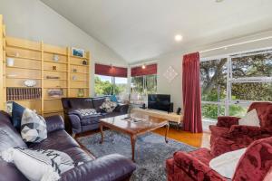 Waipu CoveFrancis Orchard Country Stay - Waipu Holiday Home的带沙发和桌子的客厅