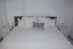 多列毛利诺斯Los Colimbos的床上有枕头,上面有爱的字眼