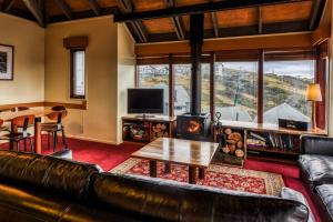 荷斯安山冈达诺拉木屋的客厅配有真皮沙发和桌子