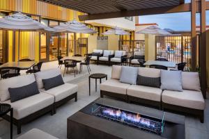 斯科茨Hyatt Place Scottsdale North的天井配有沙发、桌子和壁炉