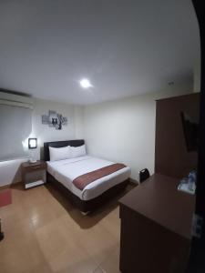 Batu MerahGrand Avira Hotel的一间卧室,卧室内配有一张大床