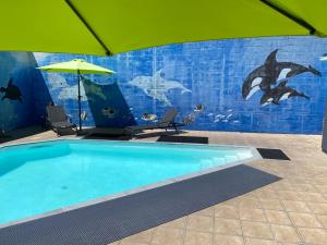 陶朗加阿姆拜塞德汽车旅馆的一个带遮阳伞和海豚壁画的游泳池