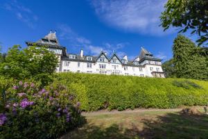 斯特拉斯佩弗The Highland Hotel by Compass Hospitality的一座城堡,位于一座种满鲜花的山顶上