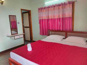科代卡纳尔MISBA HOMESTAY的一间卧室配有一张带红色毯子和镜子的床