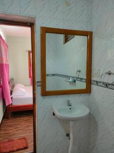 科代卡纳尔MISBA HOMESTAY的一间带水槽和镜子的浴室以及一张床