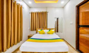 那格浦尔Itsy By Treebo - Shri Guru Service Apartment的一间卧室配有一张带黄色和彩色枕头的床