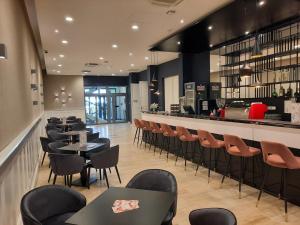 布达佩斯D50 Hotel的一间带桌椅的餐厅和一间酒吧