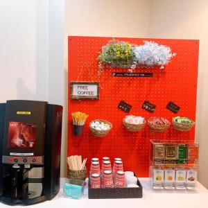 函馆弘扬函馆酒店的配有咖啡壶和一些植物的红色墙壁