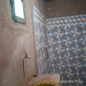 姆哈米德Chegaga Berber Camps的浴室设有蓝色和白色瓷砖淋浴。
