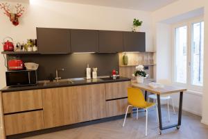 特伦托MUROS - Design Apartments in Trento的厨房配有桌子和微波炉
