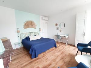 卡尔卡松Chambres d'hotes - Le Magnolia的一间卧室配有蓝色的床和一张书桌