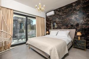 古维亚Rans Luxury Villas & Suites in Corfu with swimming pool的一间卧室设有一张床和一个大窗户