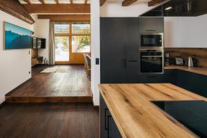 瑟弗浩斯Serfaus Alpensuites的厨房配有黑色橱柜和木制台面