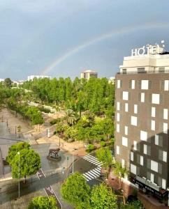 卡斯特利翁-德拉普拉纳洛拉夫人酒店的天上一带彩虹,在公园上方,有一座建筑