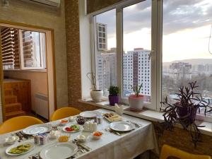 杜尚别Sunrise Apartments的窗户房间里一张带食物盘的桌子