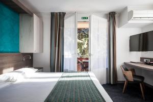 拉西约塔Hotel SPA Plage St Jean的酒店客房设有一张大床和一张书桌。