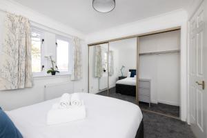 格拉斯哥JOIVY Bright 3-bed flat overlooking The Clyde的白色卧室配有床和镜子