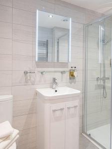 卡迪根格瓦贝特酒店的白色的浴室设有水槽和淋浴。