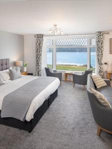 卡迪根格瓦贝特酒店的一间卧室配有床和椅子以及大窗户