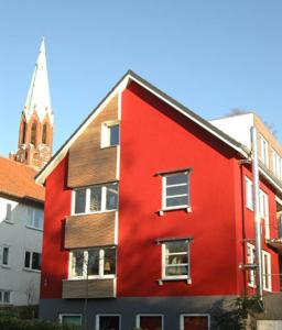 基尔Ole & Trude的一座红色的建筑,后面有一座教堂