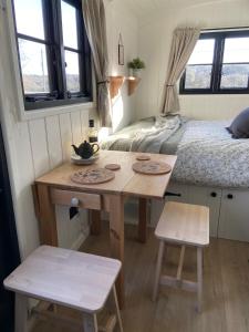 林利斯戈Peaceful Shepherd’s Hut in beautiful countryside.的小房间设有桌子和床
