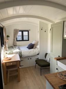 林利斯戈Peaceful Shepherd’s Hut in beautiful countryside.的一间小卧室,配有一张床和一张书桌